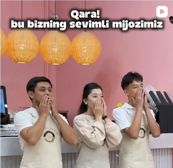 Murlati Seoul jamoasi: tilla logotipli krem rangdagi fartuklarda, rotang chiroqlar ostida